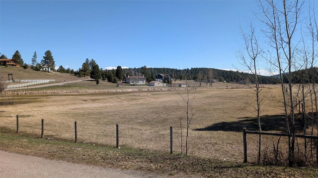 view of yard featuring fence and a rural view