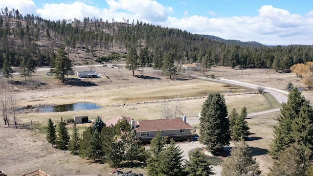 drone / aerial view featuring a water view and a wooded view