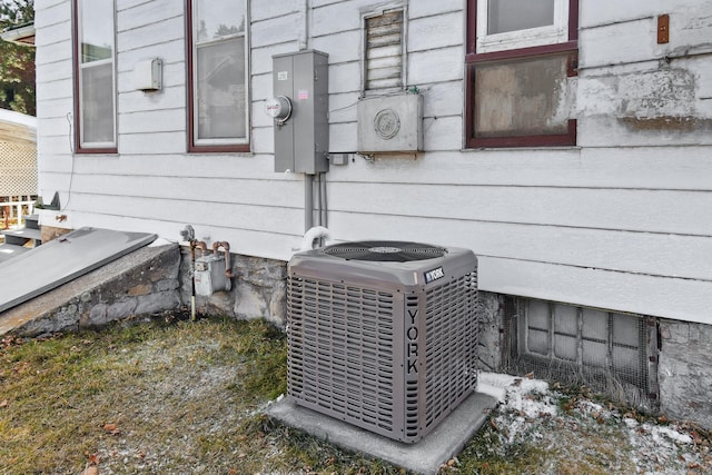 exterior details with cooling unit, a bulkhead entry, gas meter, and electric meter