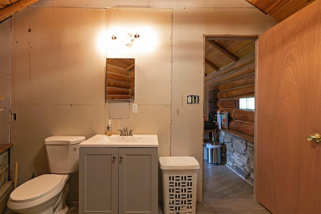 18522 Geiger Ln, Proctor, MT 59929 - bathroom with log walls, vanity, wood finished floors, toilet, and wood ceiling