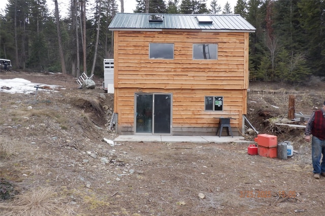 18522 Geiger Ln, Proctor, MT 59929 - rear view of house with metal roof and a forest view