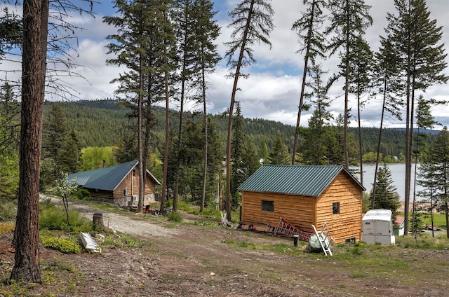 18522 Geiger Ln, Proctor, MT 59929 - view of side of property with a forest view, metal roof, and an outbuilding