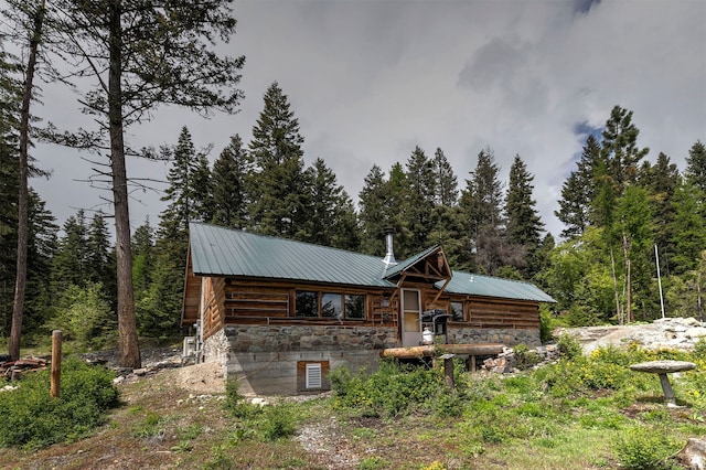 18522 Geiger Ln, Proctor, MT 59929 - back of house with stone siding, metal roof, and a view of trees