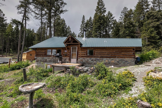 18522 Geiger Ln, Proctor, MT 59929 - log home with metal roof, stone siding, and a wooded view