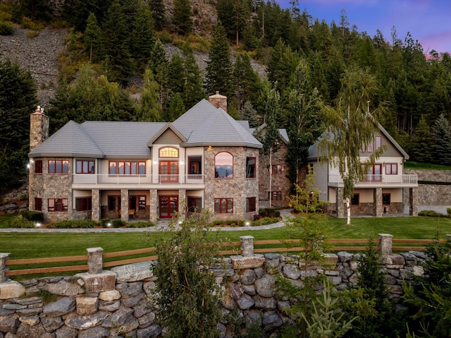 31572 Lake To Sky Dr, Bigfork, MT 59911 - rear view of property with a balcony, stone siding, and a chimney