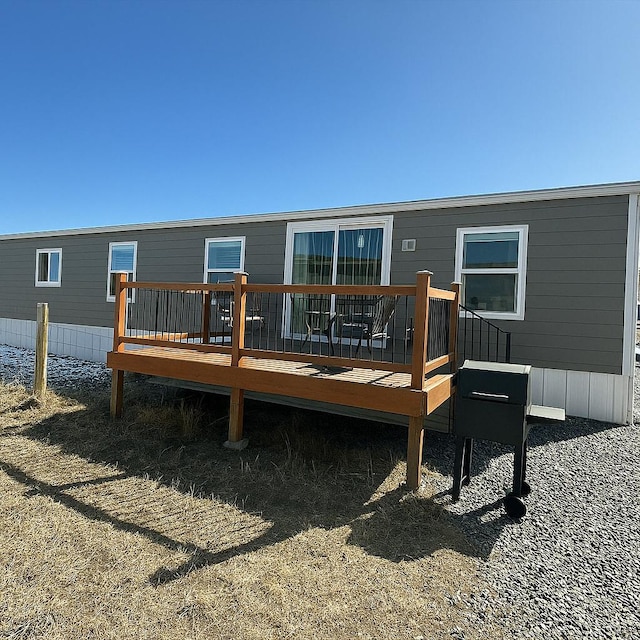 rear view of house featuring a wooden deck