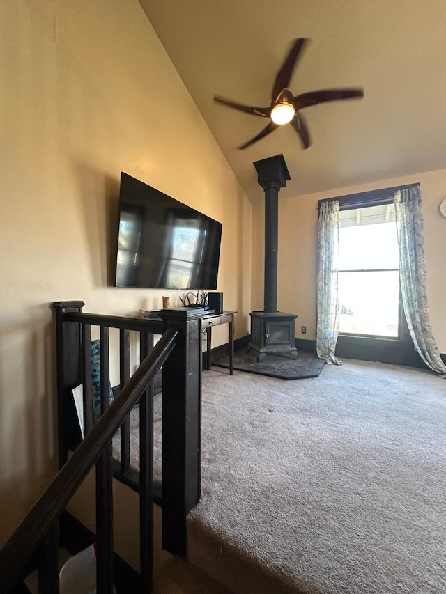 815 3rd Ave E, Kalispell, MT 59901 - unfurnished living room with lofted ceiling, carpet, a wood stove, and a ceiling fan
