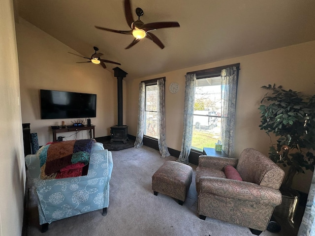815 3rd Ave E, Kalispell, MT 59901 - living room featuring a wood stove, carpet floors, lofted ceiling, and a ceiling fan
