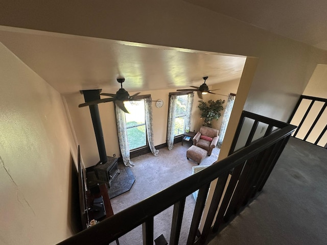 815 3rd Ave E, Kalispell, MT 59901 - living area with carpet floors, a ceiling fan, a wood stove, and baseboards