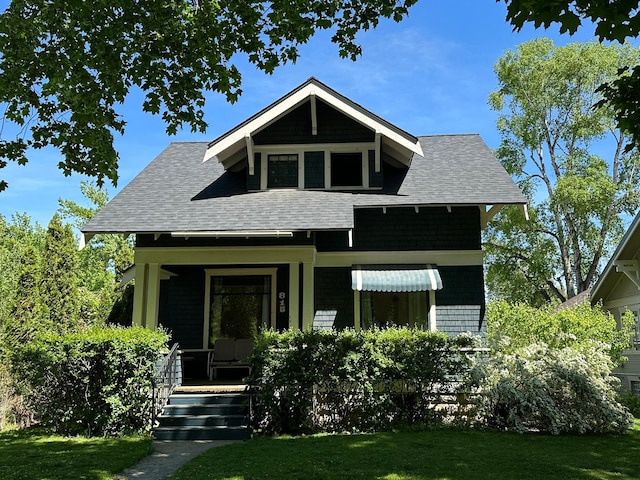 815 3rd Ave E, Kalispell, MT 59901 - view of front of property with covered porch, a front yard, and roof with shingles