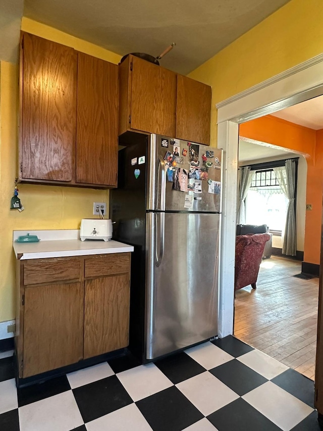 815 3rd Ave E, Kalispell, MT 59901 - kitchen with freestanding refrigerator, light countertops, light floors, and brown cabinetry