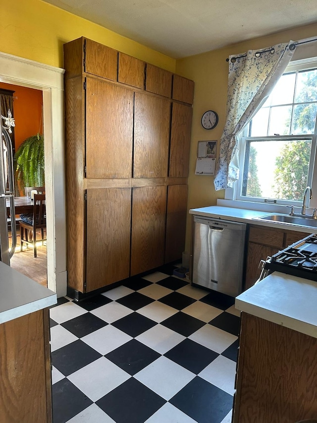 815 3rd Ave E, Kalispell, MT 59901 - kitchen featuring dishwasher, light flooring, a sink, range with gas cooktop, and light countertops