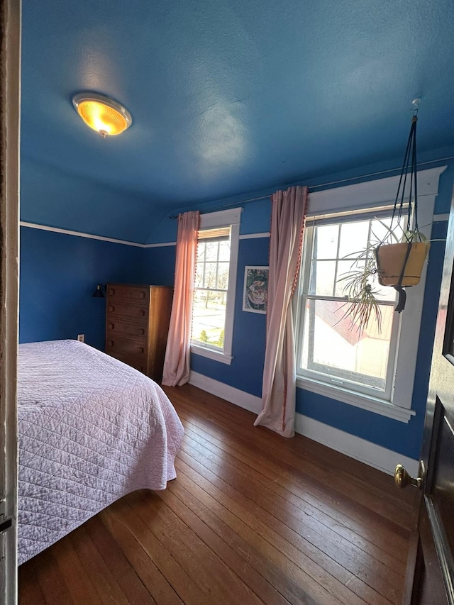 815 3rd Ave E, Kalispell, MT 59901 - bedroom with wood-type flooring, baseboards, lofted ceiling, and a textured ceiling