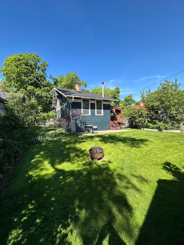 815 3rd Ave E, Kalispell, MT 59901 - back of house with an outdoor fire pit, a chimney, stairway, and brick siding