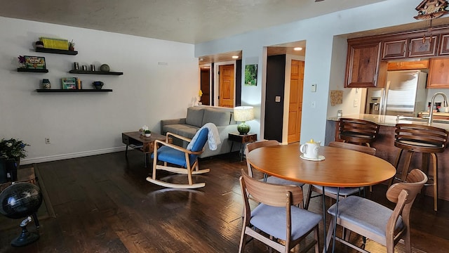 dining space featuring baseboards and dark wood-style floors
