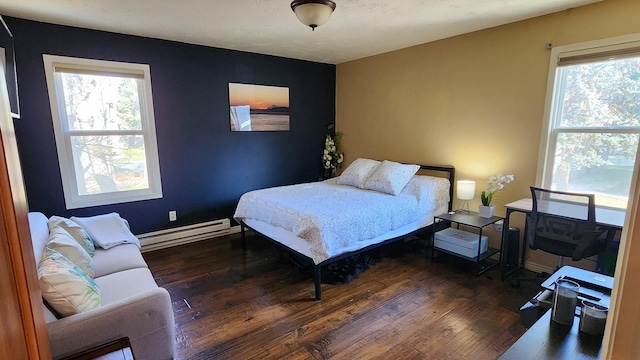 bedroom with wood finished floors and a baseboard radiator