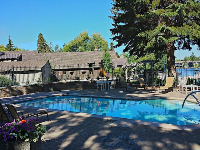view of swimming pool with fence, a fenced in pool, a pergola, and a patio area