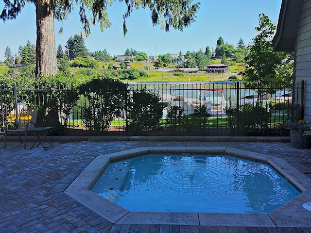 view of pool with fence, a swimming pool, and a patio