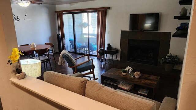 living room featuring a ceiling fan, wood finished floors, and a fireplace