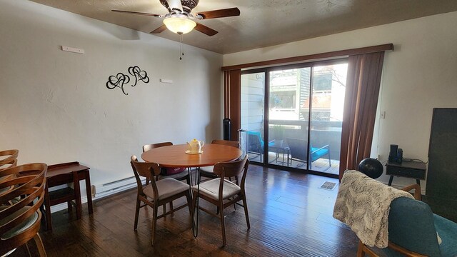 dining area with ceiling fan, a baseboard heating unit, dark wood finished floors, and visible vents