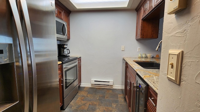 270 Bridge St Unit Qc1-203, Bigfork, MT 59911 - kitchen with appliances with stainless steel finishes, baseboard heating, stone finish flooring, and light stone counters