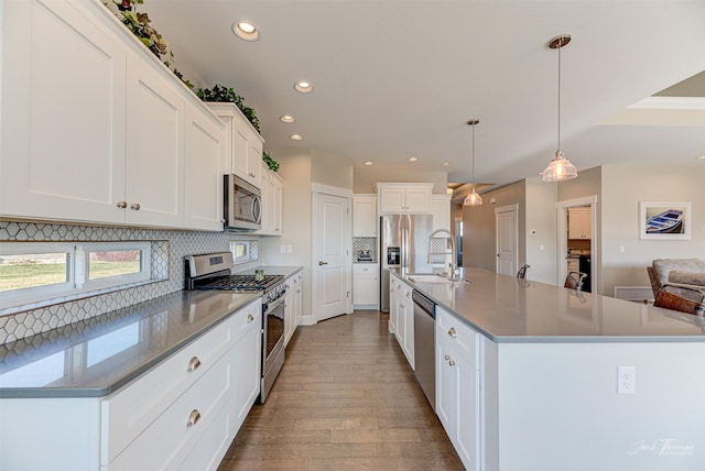 2883 Alpine View Loop, Helena, MT 59601 - kitchen featuring stainless steel appliances, a sink, tasteful backsplash, dark wood-style floors, and a spacious island