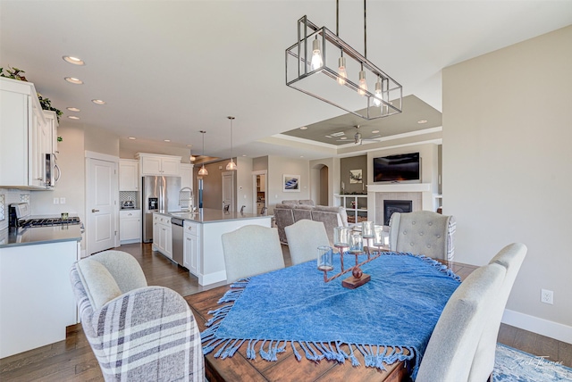 2883 Alpine View Loop, Helena, MT 59601 - dining area with dark wood finished floors, recessed lighting, baseboards, a tile fireplace, and a tray ceiling