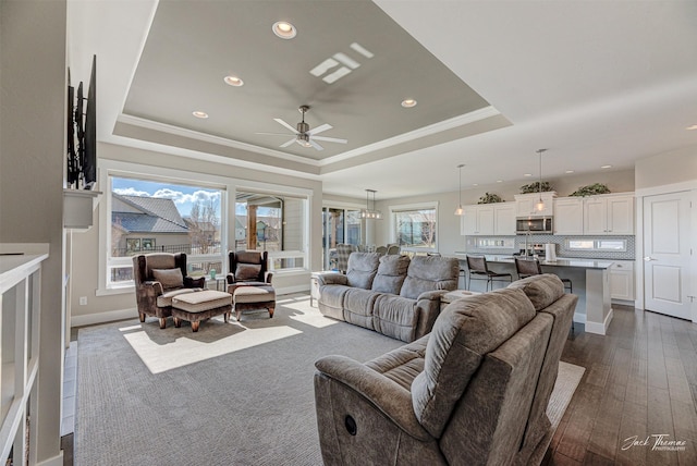 2883 Alpine View Loop, Helena, MT 59601 - living room featuring a tray ceiling, ornamental molding, recessed lighting, ceiling fan, and dark wood-style floors