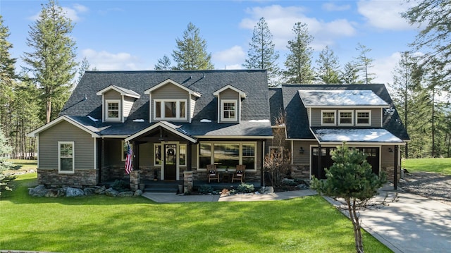 255 Windsor Ct, Bigfork, MT 59911 - rear view of house featuring a yard, covered porch, stone siding, a garage, and a shingled roof