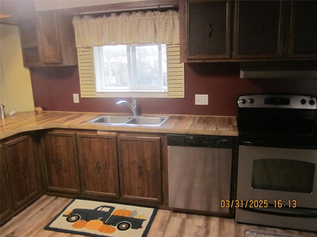 4612 Richlie St, Missoula, MT 59808 - kitchen with appliances with stainless steel finishes, light countertops, extractor fan, and light wood-type flooring