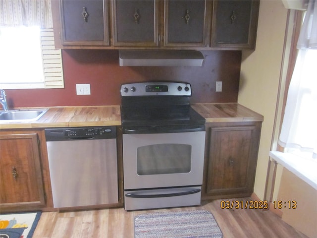 4612 Richlie St, Missoula, MT 59808 - kitchen featuring appliances with stainless steel finishes, range hood, butcher block counters, and light wood finished floors