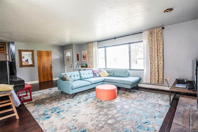 living area with a textured ceiling, baseboard heating, wood finished floors, and baseboards