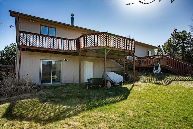 rear view of house with a yard, a wooden deck, and stairs