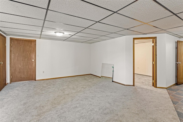 finished below grade area with carpet floors, baseboards, and a paneled ceiling