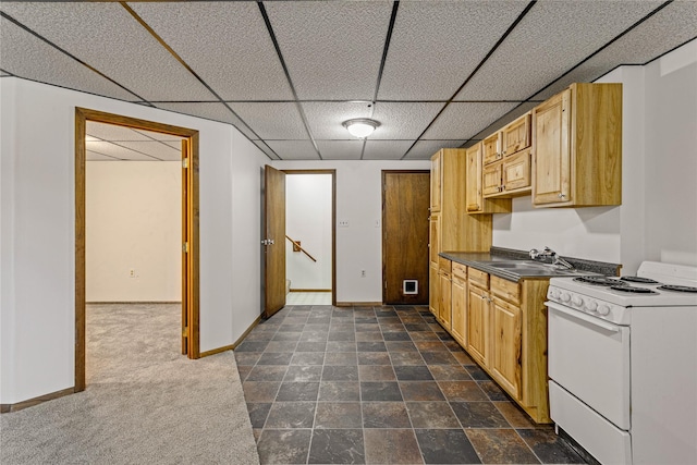 kitchen featuring baseboards, dark countertops, stone finish floor, white electric range oven, and a sink