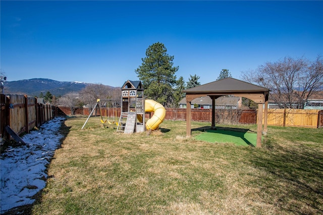 view of yard with a mountain view, a fenced backyard, a gazebo, and a playground