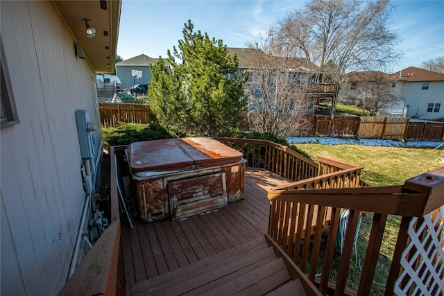 wooden deck featuring fence, a hot tub, and a lawn