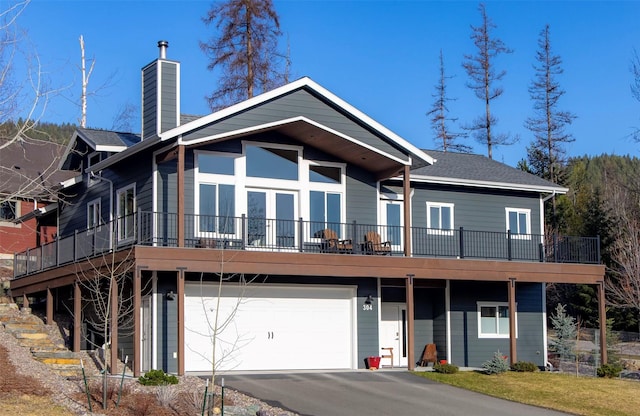 304 Stumptown Loop, Whitefish, MT 59937 - view of front of house featuring a garage, a chimney, and asphalt driveway