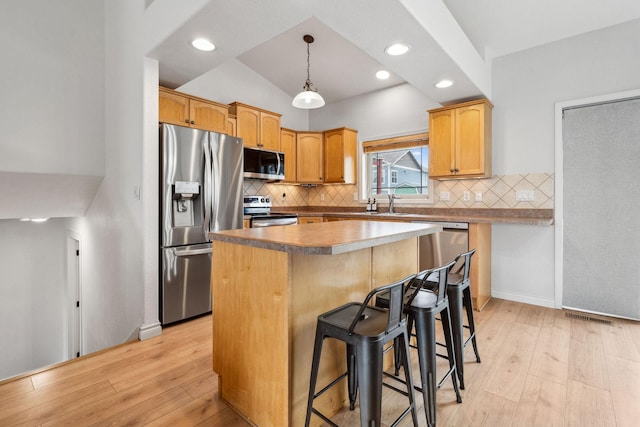 425 Northridge Dr, Kalispell, MT 59901 - kitchen with appliances with stainless steel finishes, a kitchen breakfast bar, a kitchen island, and light wood finished floors