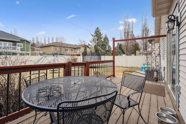 425 Northridge Dr, Kalispell, MT 59901 - deck with cooling unit, a trampoline, a fenced backyard, and outdoor dining area