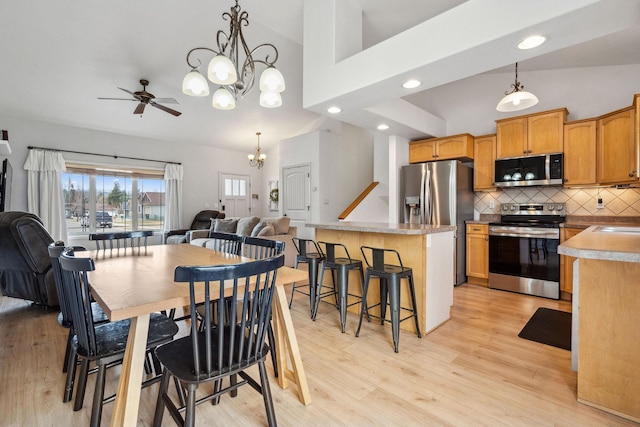 425 Northridge Dr, Kalispell, MT 59901 - dining area with high vaulted ceiling, recessed lighting, light wood finished floors, and ceiling fan with notable chandelier