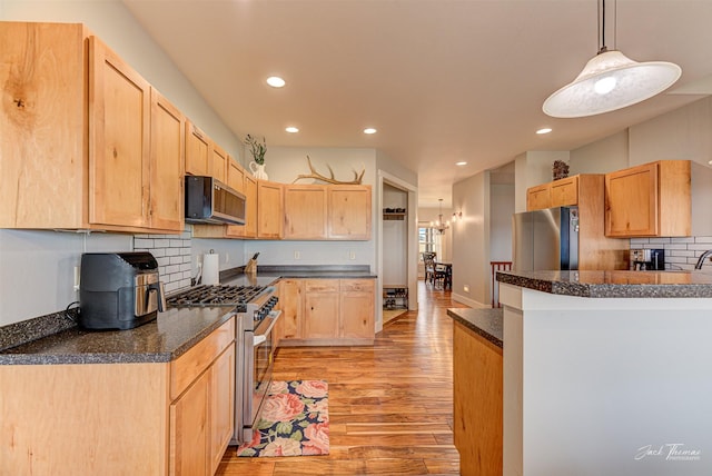 2160 Crested Wheat Loop, East Helena, MT 59635 - kitchen featuring light brown cabinetry, light wood finished floors, dark countertops, and stainless steel appliances