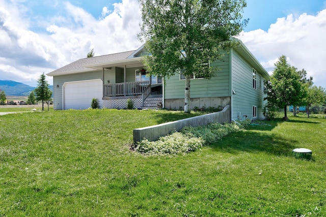 24 Spruce Grove Rd, East Helena, MT 59635 - view of front of home with a porch, a front yard, a garage, and a mountain view