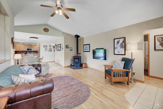 24 Spruce Grove Rd, East Helena, MT 59635 - living room with light wood-style flooring, a wood stove, a ceiling fan, and vaulted ceiling