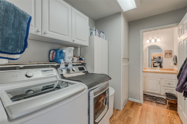 675 Pebble Dr, Kalispell, MT 59901 - laundry room featuring washing machine and clothes dryer, cabinet space, and light wood-style flooring