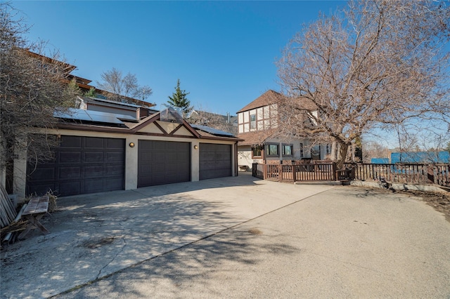 521 Clarke St, Helena, MT 59601 - view of front of home featuring solar panels, stucco siding, concrete driveway, and a deck