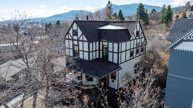 521 Clarke St, Helena, MT 59601 - rear view of property featuring roof with shingles, a mountain view, and stucco siding