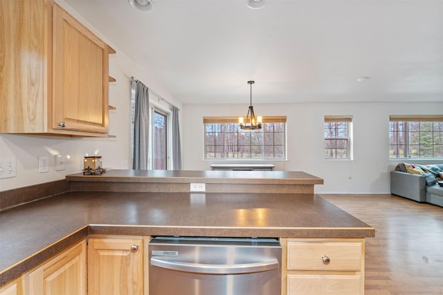 100 Forest Ridge Dr Unit B, Whitefish, MT 59937 - kitchen featuring light brown cabinetry, dark countertops, a peninsula, and light wood finished floors