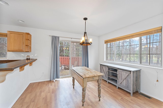 100 Forest Ridge Dr Unit B, Whitefish, MT 59937 - dining area featuring a chandelier, light wood finished floors, and baseboards