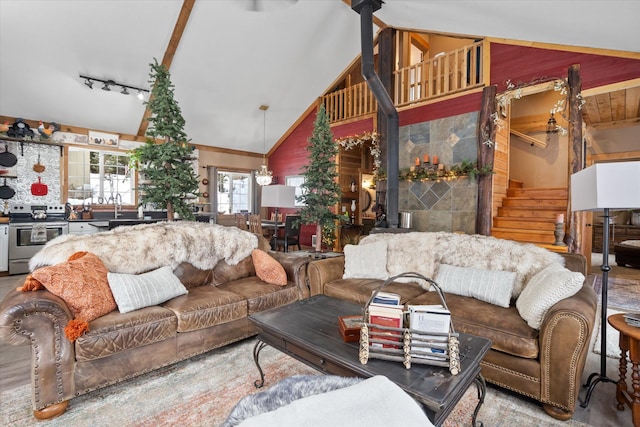 4695 Star Meadow Rd, Whitefish, MT 59937 - living area featuring wooden walls, high vaulted ceiling, stairs, and track lighting